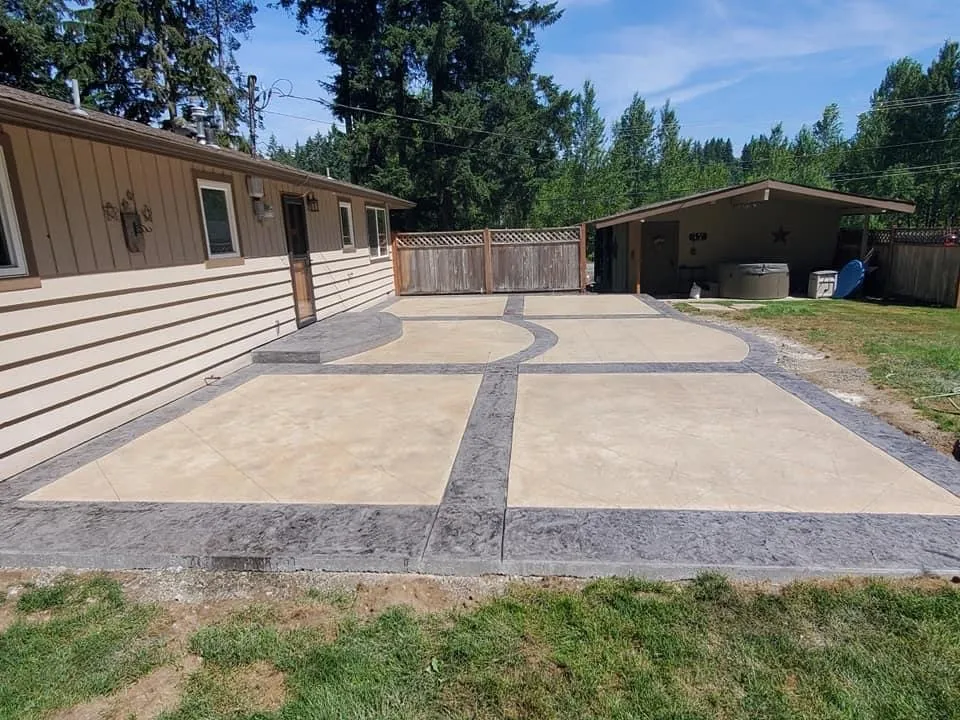 Decorative concrete patio with curved charcoal borders.