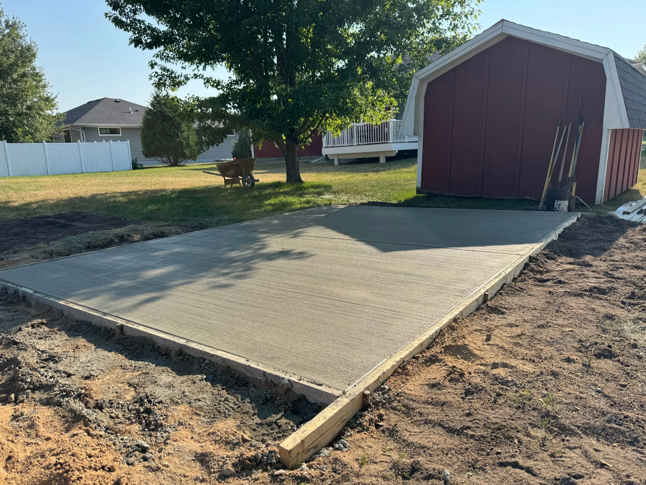 New concrete pad alongside a storage shed.