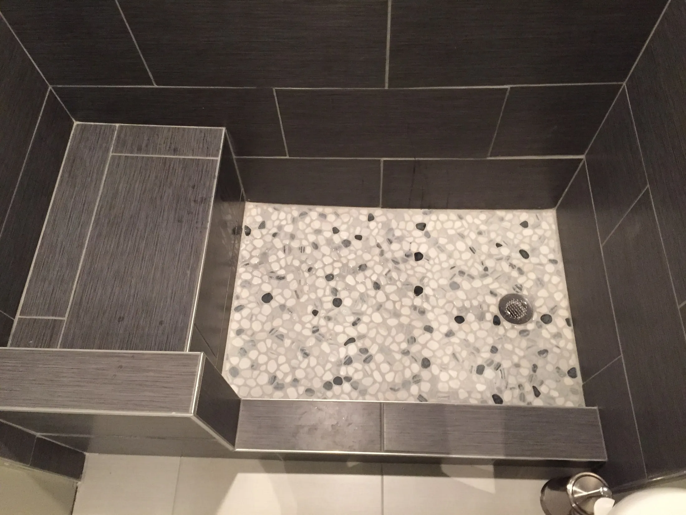 Accent band detail in the charcoal tile shower.