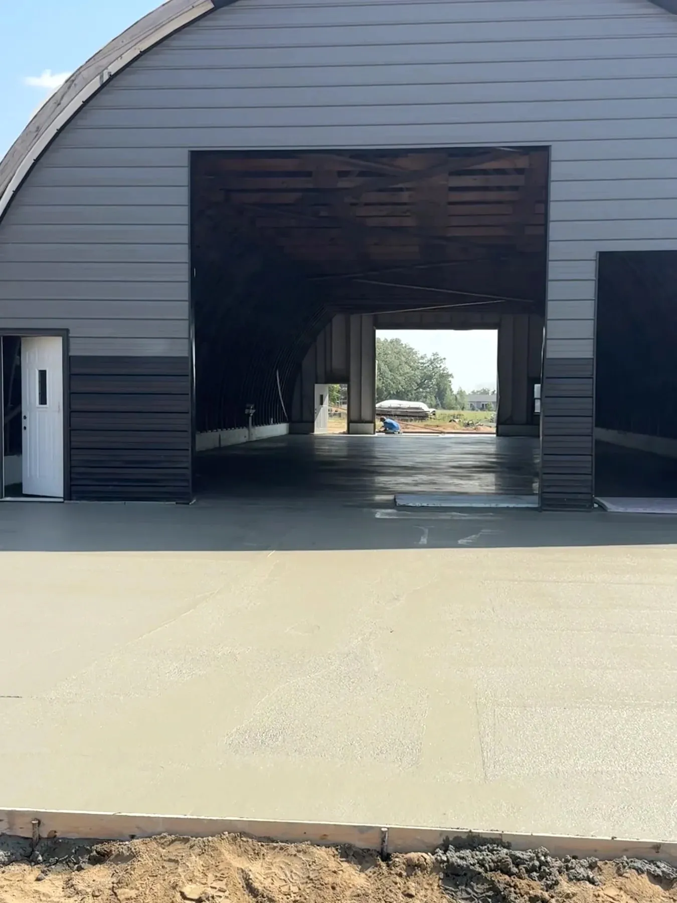 July 2026 Quonset exterior apron — not an interior-floor photograph.