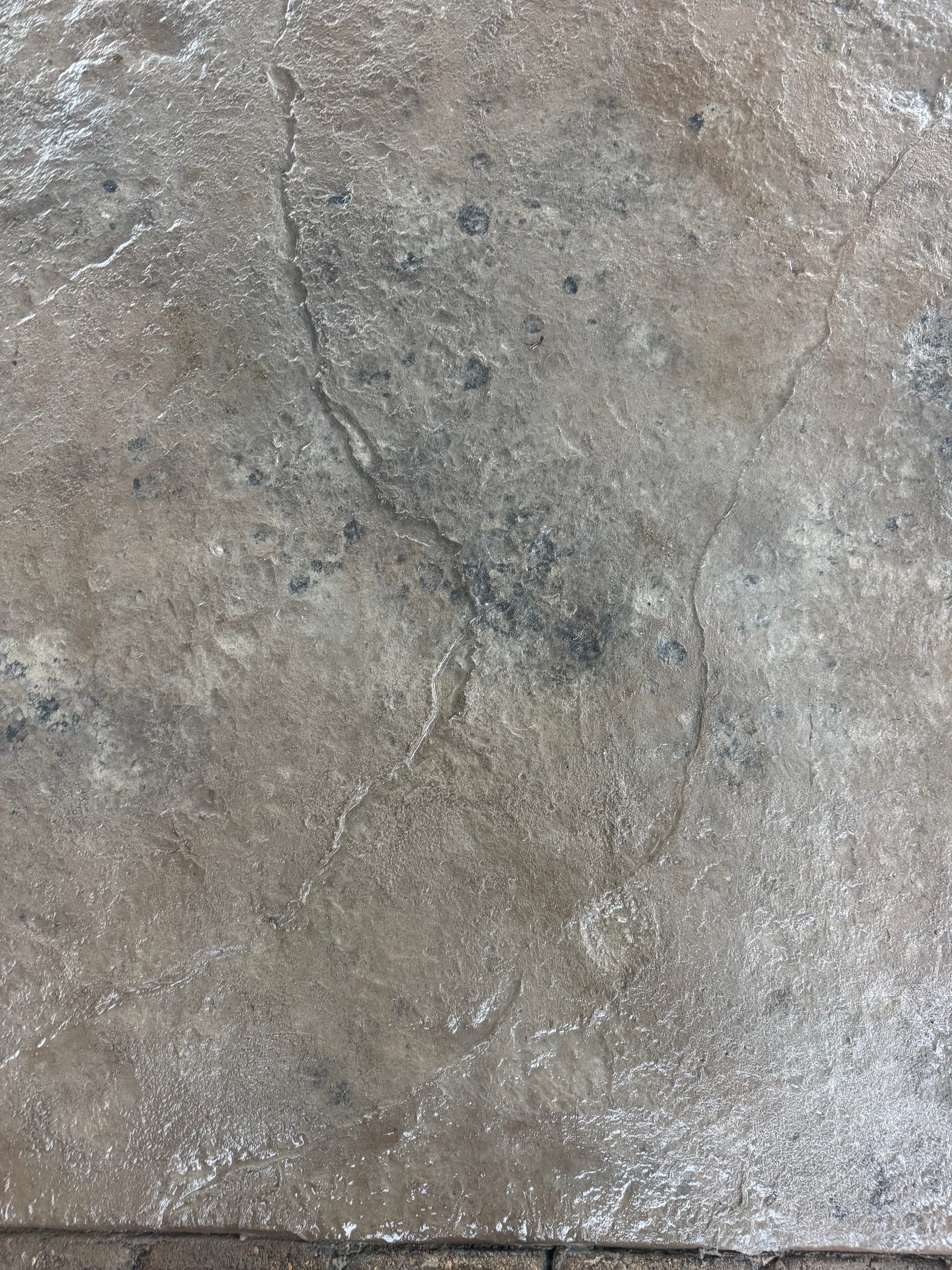Close-up of stamped concrete patio surface with stone texture pattern in west-central Minnesota.