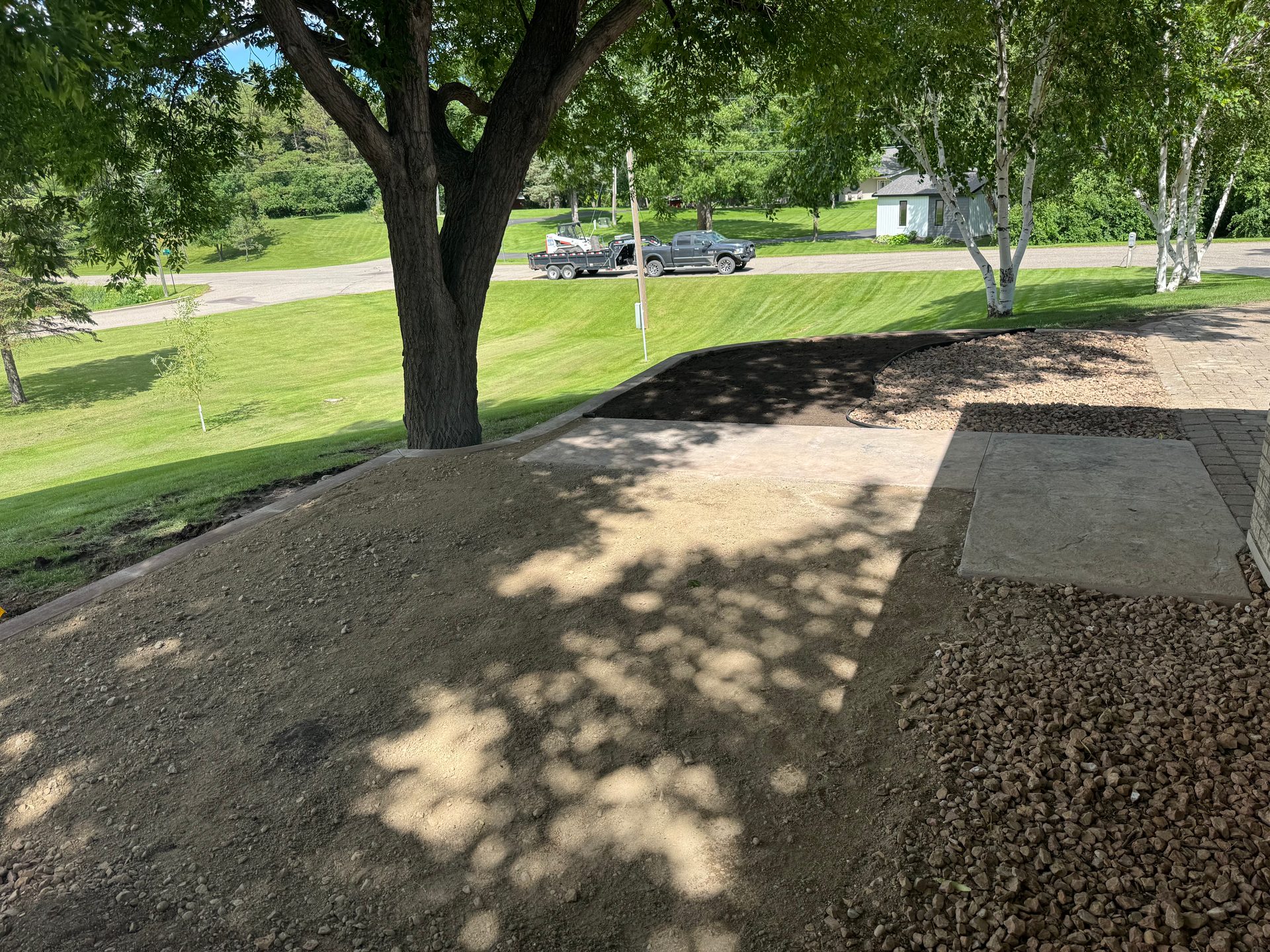 Wide aerial view of stamped concrete patio and decorative border installation at residential property in west-central Minnesota.