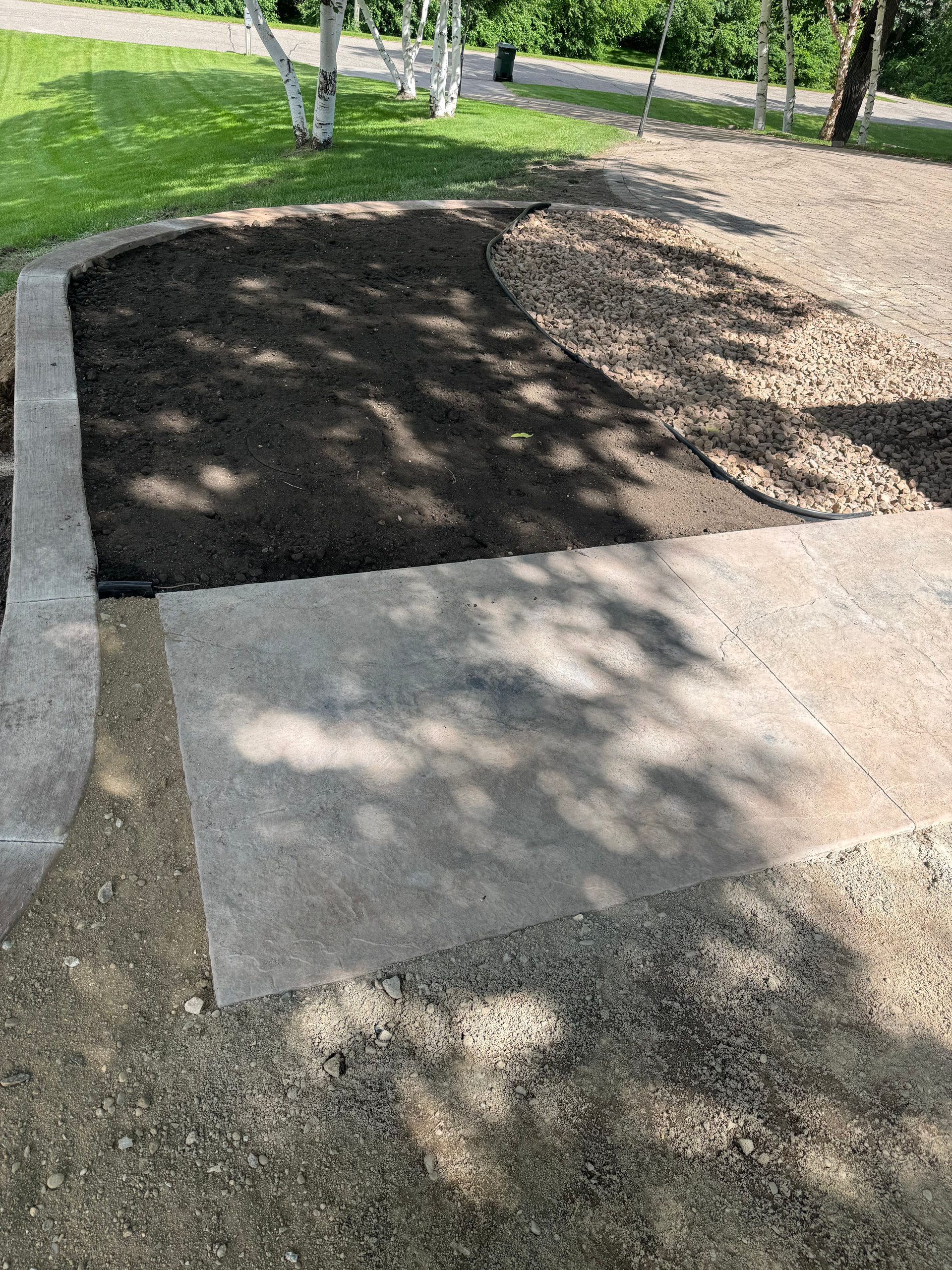 Stamped concrete patio section with stone pattern finish in dappled light in west-central Minnesota.